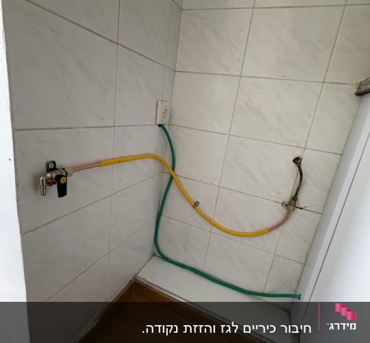 חיבורי גז על קיר עם אריחים לבנים